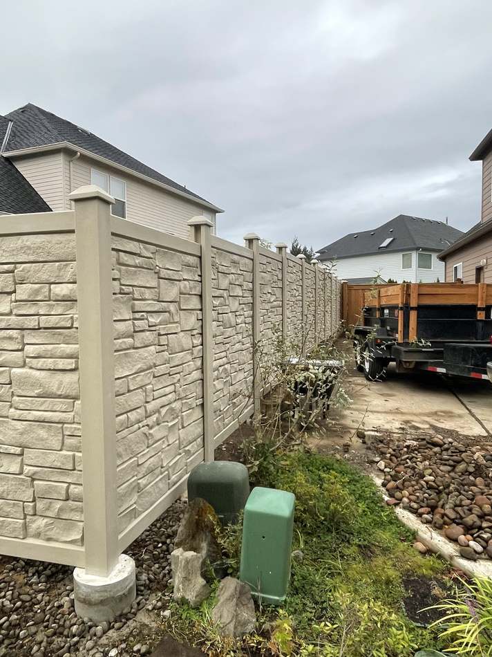 Composite stone-look privacy fence row along driveway by Gravelle Construction