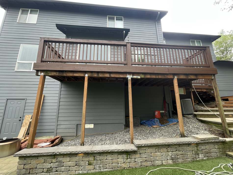 Two-tier deck before rebuild, showing old brown deck and railing