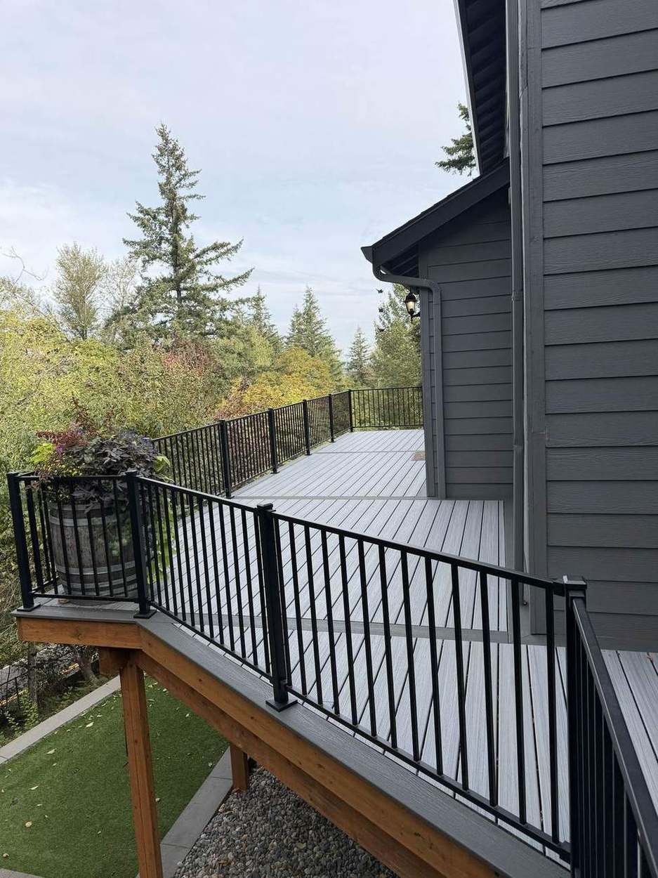 Finished upper deck walkway along black metal railing with composite decking