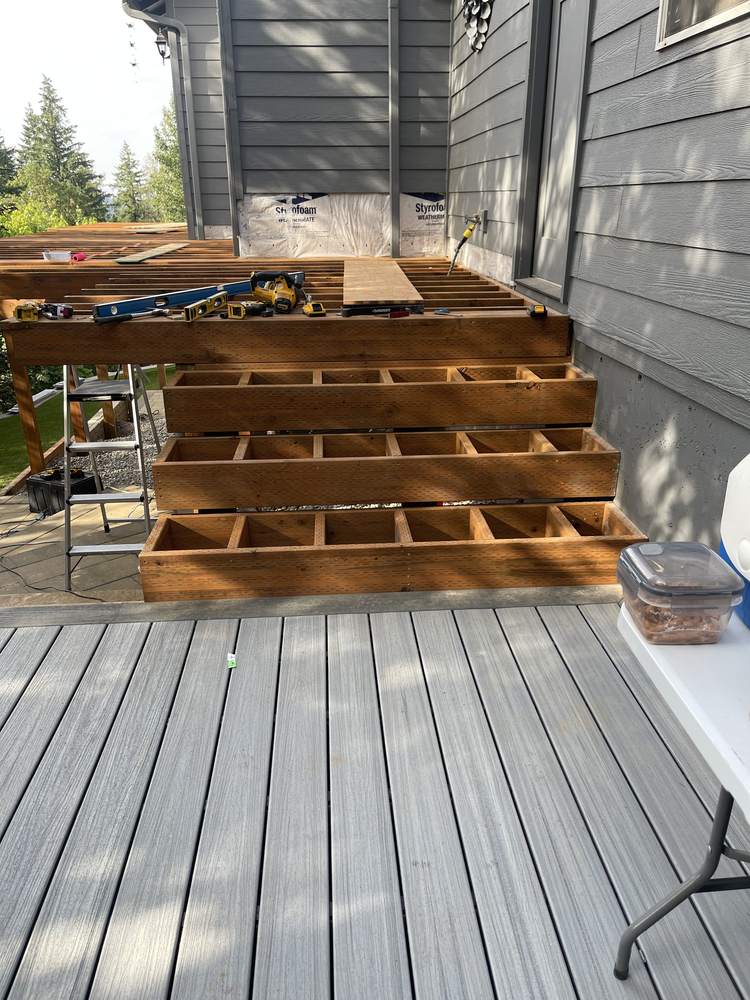 Open stair riser framing before composite treads installed on two-tier deck stairs