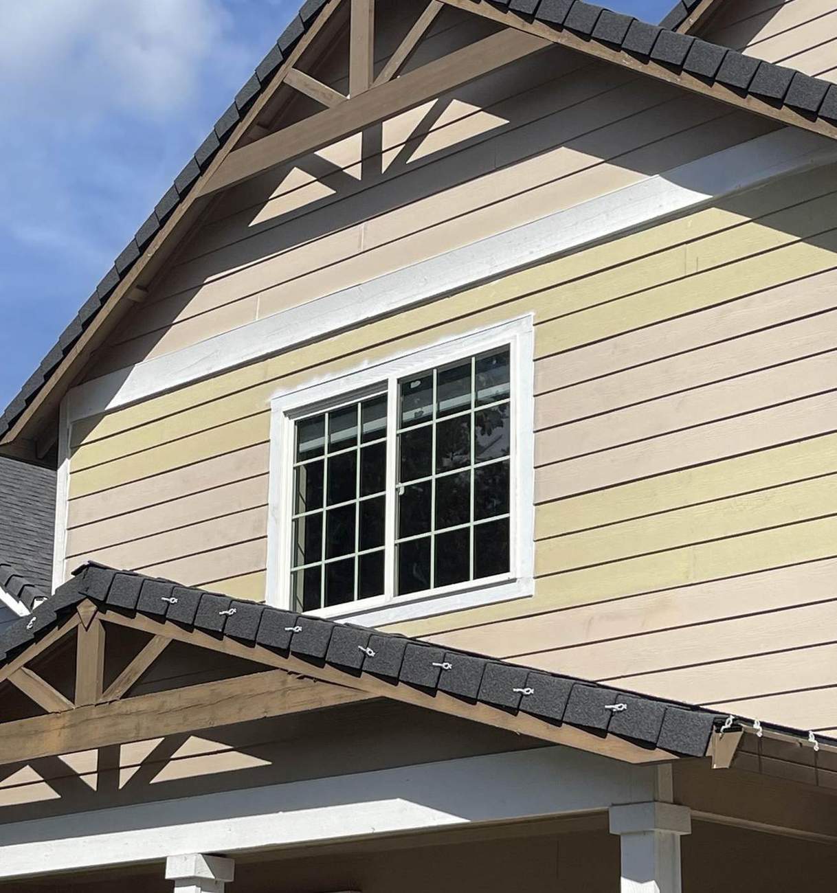 Two-tone Craftsman-style siding and white window trim installed by Gravelle Construction
