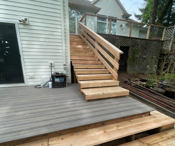 New composite lower deck with cedar stairs and railing built by Gravelle Construction