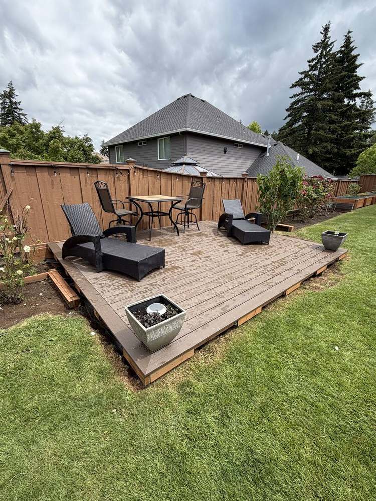 Ground-level backyard deck with cedar privacy fence built by Gravelle Construction