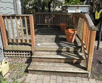 Worn wood deck steps and railing before rebuild