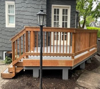 New stained wood deck railing viewed from the lamp post, built by Gravelle Construction