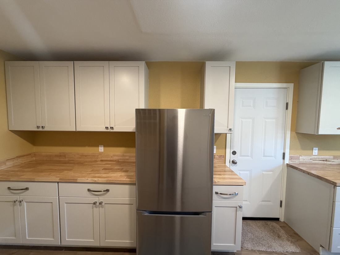 Renovated hobby room with new white cabinets and butcher block countertops
