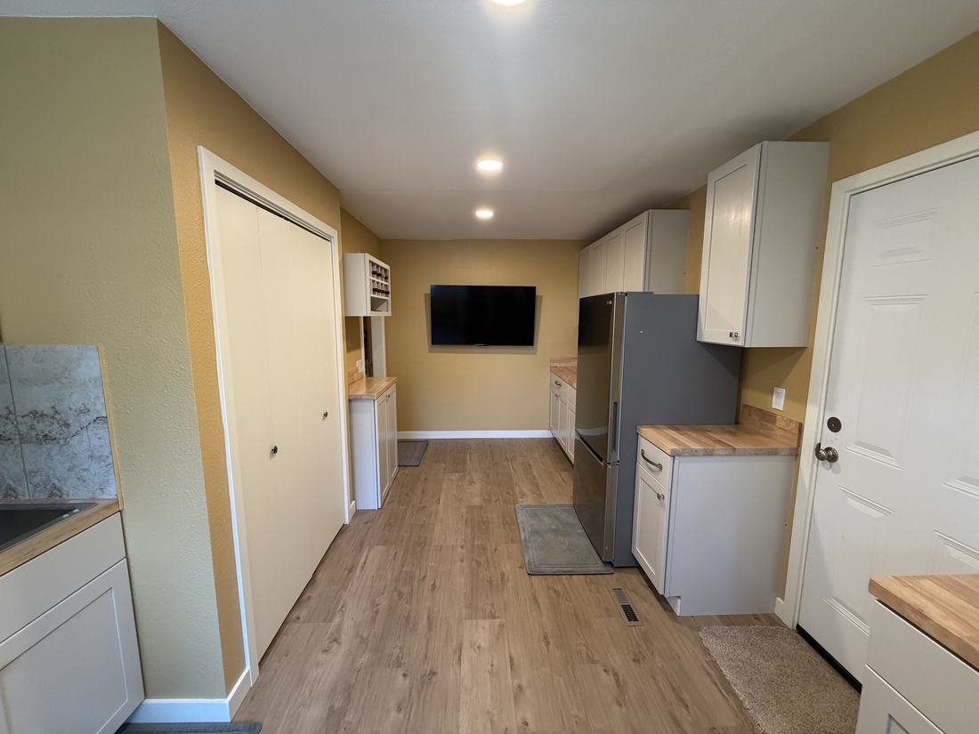 Renovated hobby room laundry area with new sink, tile backsplash and cabinetry