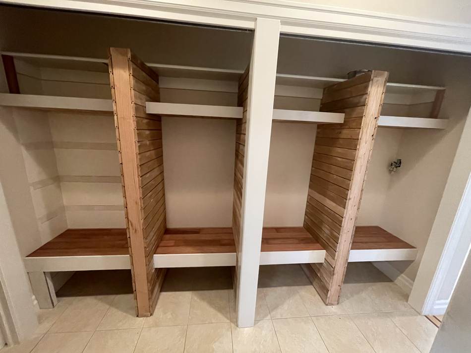 Finished entryway cubbies with open storage and coat hooks by Gravelle Construction